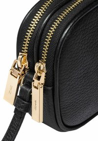 Czarna skórzana torba o teksturowanej powierzchni, z podwójnymi złotymi suwakami i prostokątnym kształtem, wyposażona w smukły pasek. Obecne są złote akcenty.