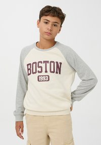 Pullover grigio e crema con il testo "BOSTON 1993" in bordeaux, maniche raglan, scollo rotondo e polsini e orlo a coste.