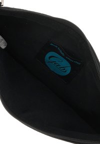 Borsa in tessuto nero con chiusura a zip. L'interno presenta un'etichetta blu con il logo "Gabs". Texture morbida, design minimalista.