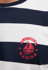 Jūros mėlynos ir baltos juostelės medvilninė marškinėlė su apvalia iškirpte ir raudonu grafiniu atspaudu su jachta bei tekstu "BIG STAR MARINA".