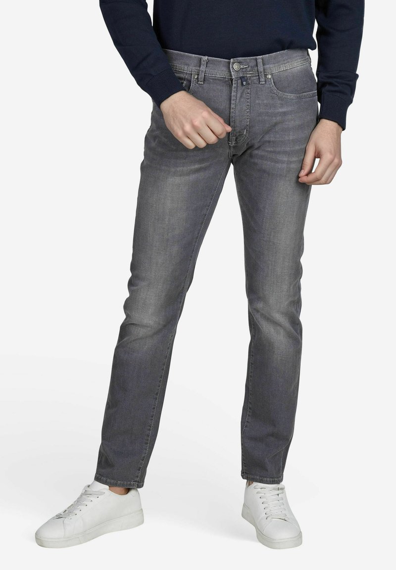 Grijze denim jeans met een slim fit, met een medium taillehoogte, standaard vijf-pocket ontwerp en contrasterende stiksels, gecombineerd met witte sneakers.