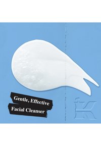 Hvit, kremet ansiktsrens med bobler, formet som en dråpe, på en blå bakgrunn. Teksten fremhever "Skånsom, effektiv ansiktsrens."