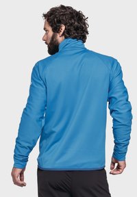 Blaues Fleece-Jackett mit hohem Kragen und langen Ärmeln, aus strukturiertem Stoff und in taillierter Passform.