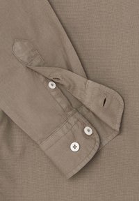 Manica di camicia in cotone di colore kaki tenue, con chiusura a un bottone e cuciture a contrasto. Tessuto morbido con taglio classico.