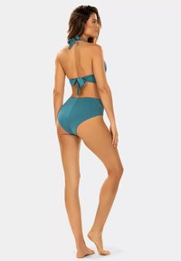 Sukienka kąpielowa w kolorze niebiesko-zielonym z dwuczęściowym fasonem, z dekoltem na halter i wiązanym z tyłu zapięciem. Wysokie majtki, gładka tekstura i prosta sylwetka.