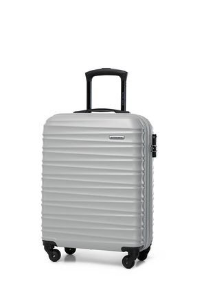 Silver hard-shell suitcase with textured ridges, black retractable handle, and four spinner wheels. Durable design with logo detail.