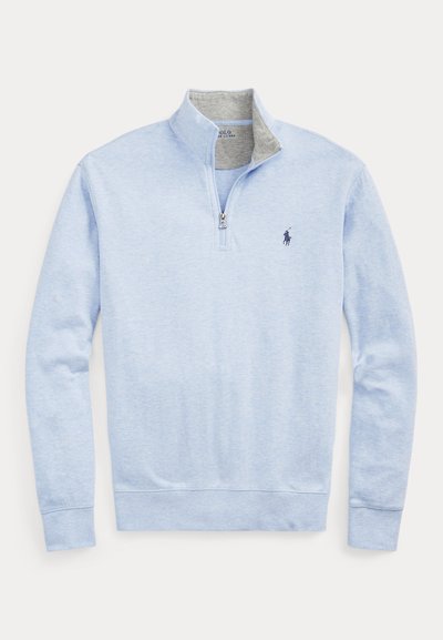 Svetlo modra pulover z dolgimi rokavi s četrtinsko zadrgo, stoječi ovratnik in majhen mornarsko modri logotip na levem prsnem delu, zložen notranji ovratnik iz sive tkanine.