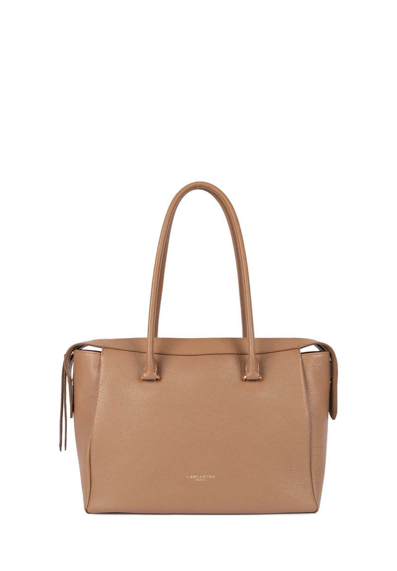 Sac fourre-tout en cuir fauve avec deux poignées supérieures, fermeture éclair et logo discrètement embossé. Surface texturée avec une forme structurée.