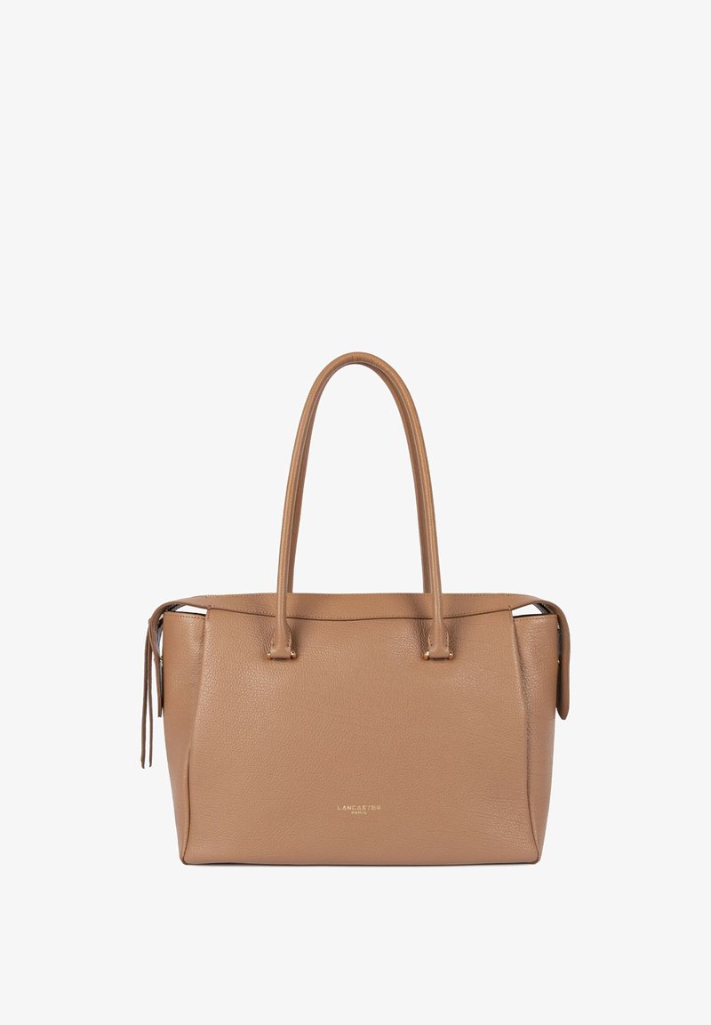 Sac fourre-tout en cuir fauve avec deux poignées supérieures, fermeture éclair et logo discrètement embossé. Surface texturée avec une forme structurée.