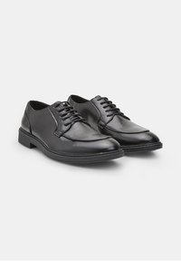 Chaussures habillées en cuir noir avec une finition lisse, un bout arrondi et un laçage à six œillets. Dispose d'une semelle en caoutchouc noir à profil bas.