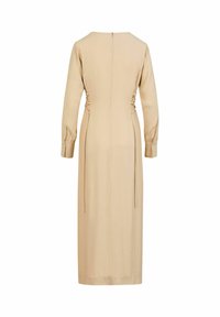 Robe midi beige à manches longues avec fermeture éclair au dos, laçage latéral style corset et poignets boutonnés, vue de dos sur fond blanc.