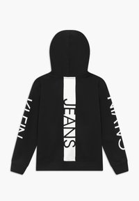 Sudadera negra de algodón, con una gran franja vertical blanca con la palabra "JEANS" impresa, y con puños y dobladillo acanalados.
