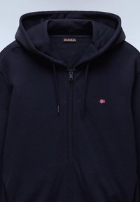 Felpa con cappuccio navy con zip, realizzata in tessuto morbido, con cappuccio regolabile tramite coulisse e piccolo dettaglio di bandiera ricamata sul petto.