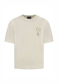 Camiseta de algodón color crema con mangas cortas, que presenta un gráfico de corazón verde y un logo en el lado izquierdo. Corte regular.