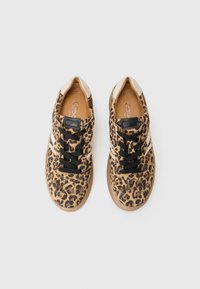 Sneakers med leopardmønster, laget av teksturert stoff, med svarte snører, kontrasterende hvite detaljer og en beige tunge. Gummisåle for godt grep.