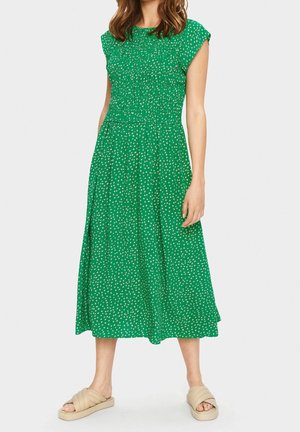 Grünes Midi-Kleid mit gerafftem Oberteil, kurzen Ärmeln und weißen Punkten. Hergestellt aus leichtem Stoff mit einem fließenden Rock und lässiger Passform.