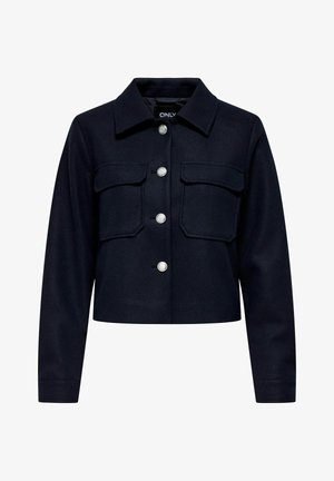 Námornícky skrátený kabát s golierom, dvoma náprsními vreckami a striebornými cvokmi na zapínanie. Textúrovaná tkanina.