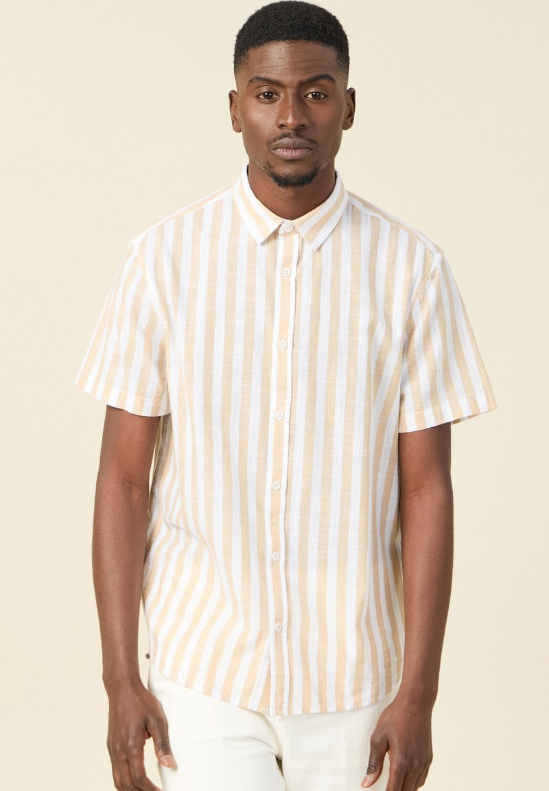 Camicia a maniche corte con bottoni, caratterizzata da strisce verticali bianche e giallo chiaro, realizzata in tessuto leggero, con una texture morbida.