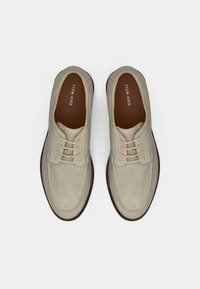 Γκρι σουέτ παπούτσια με στρογγυλή μύτη, σχέδιο δέσιμο και αντίθετη σκοτεινή καφέ σόλα. Το εσωτερικό διαθέτει καφέ πάτο με σήμανση.