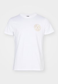 Λευκό βαμβακερό T-shirt με στρογγυλή λαιμόκοψη και κοντά μανίκια, με κυκλικό χρυσό λογότυπο στην αριστερή πλευρά του στήθους.