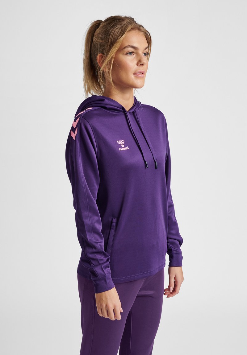 Paarse hoodie van een gladde stof met een trekkoordkap. Voorzien van roze chevron accenten op de schouders en een voorkant zak. Logo op de borst.