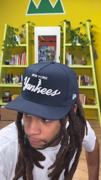 Navy blue New York Yankees cap with embroidered logo. Features a structured design, flat brim, and adjustable snapback closure.