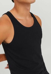 Black cotton tank top with a round neckline and sleeveless design. Smooth texture and fitted shape suitable for layering or casual wear.