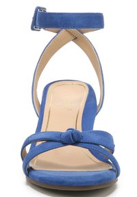 Blauwe suède hoge hak sandaal met een geknoopte voorband, enkelgesp en kruislingse ontwerp. Gladde, beige binnenzool met gouden accenten.