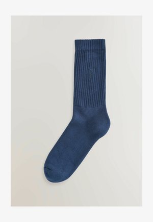 Calzino blu navy con texture a coste, dotato di una punta liscia e una cuffia rinforzata. Progettato per il comfort con un delicato dettaglio del logo.