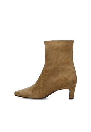 Brauner Wildleder-Stiefelette mit spitz zulaufender Zehenpartie und niedrigem, geschwungenem Absatz vor weißem Hintergrund.