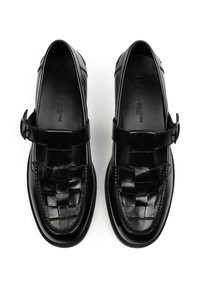 Pair of black leather woven loafers with a buckle strap, viewed from above on a white background.