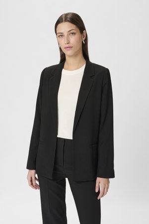 Schwarzes Blazer mit maßgeschneidertem Design, mitreissenden Revers und zwei Fronttaschen, kombiniert mit einem weißen Rundhalsausschnitt-Shirt. Glatter, strukturierter Stoff.