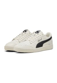 Hvide lædersneakers med en tekstureret sort stripe, perforeret tåboks og hvid gummisul; inkluderer sorte logo detaljer på tungen.