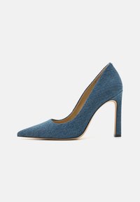 Džínsový textúrovaný vysoký podpätok s špicatou špičkou v tmavomodrej farbe, s elegantným siluetom a zužujúcim sa stiletto podpätkom, ktorý má kontrastný čierny kryt na podpätku.