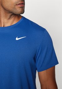 Camiseta azul de manga corta hecha de tela texturizada, con el logo swoosh de Nike en blanco en la parte superior izquierda del pecho.