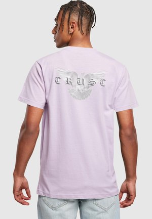 Light purple cotton t-shirt featuring a large white dove graphic with the text "TRUST" in stylized silver letters on the back.
