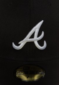Cappello da baseball nero con logo "A" ricamato bianco. Presenta un tessuto texturizzato e un'etichetta circolare dorata contrassegnata "59FIFTY" con taglia 7 1/4.