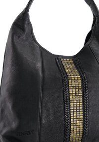 Zwarte leren handtas met textuurpanelen, centrale verticale gouden tegelversiering en een enkele schouderriem.
