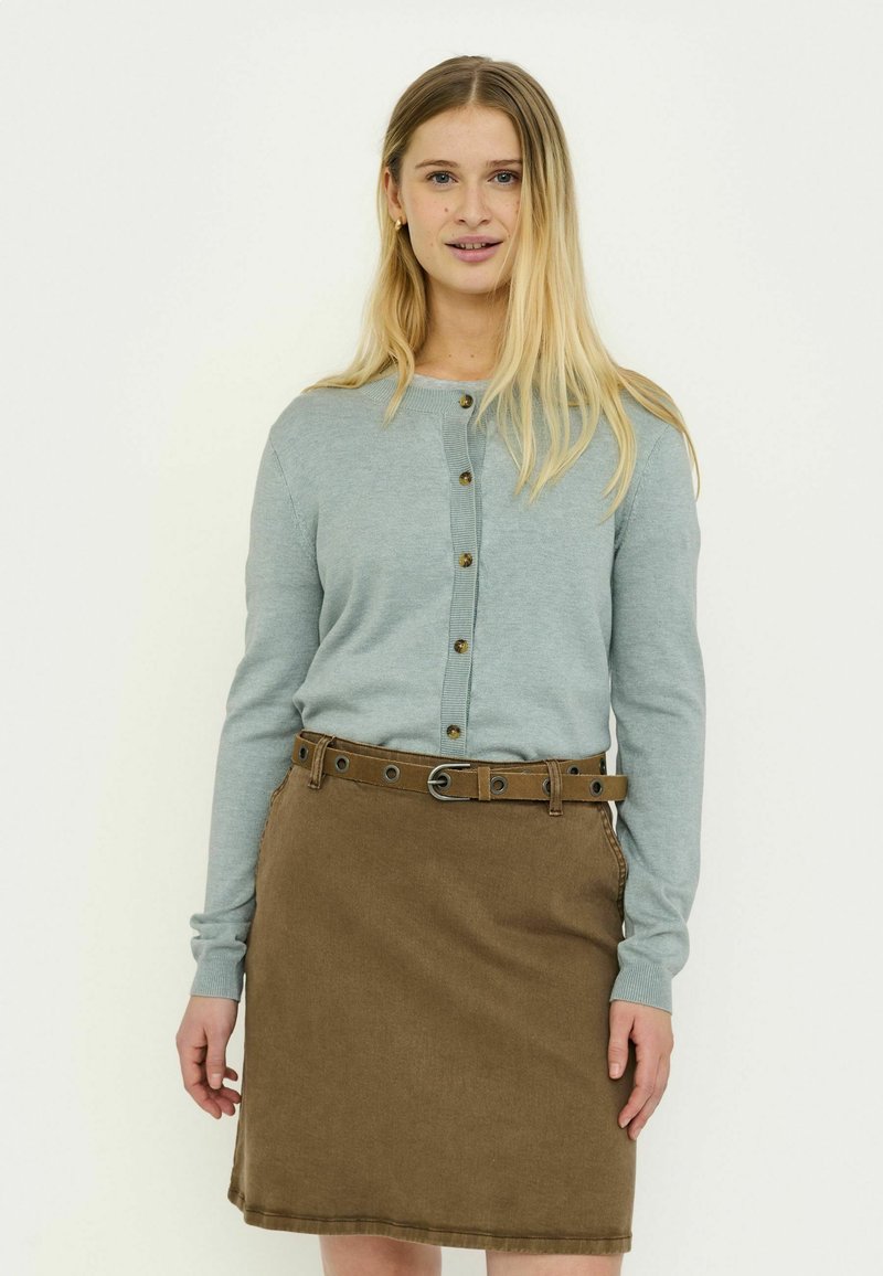 Hele sinine kampsun ümmarguse kaelusega ja nööpidega, kombineeritud pruuni teksaseelikuga, millel on vöö ja metallist detailid.