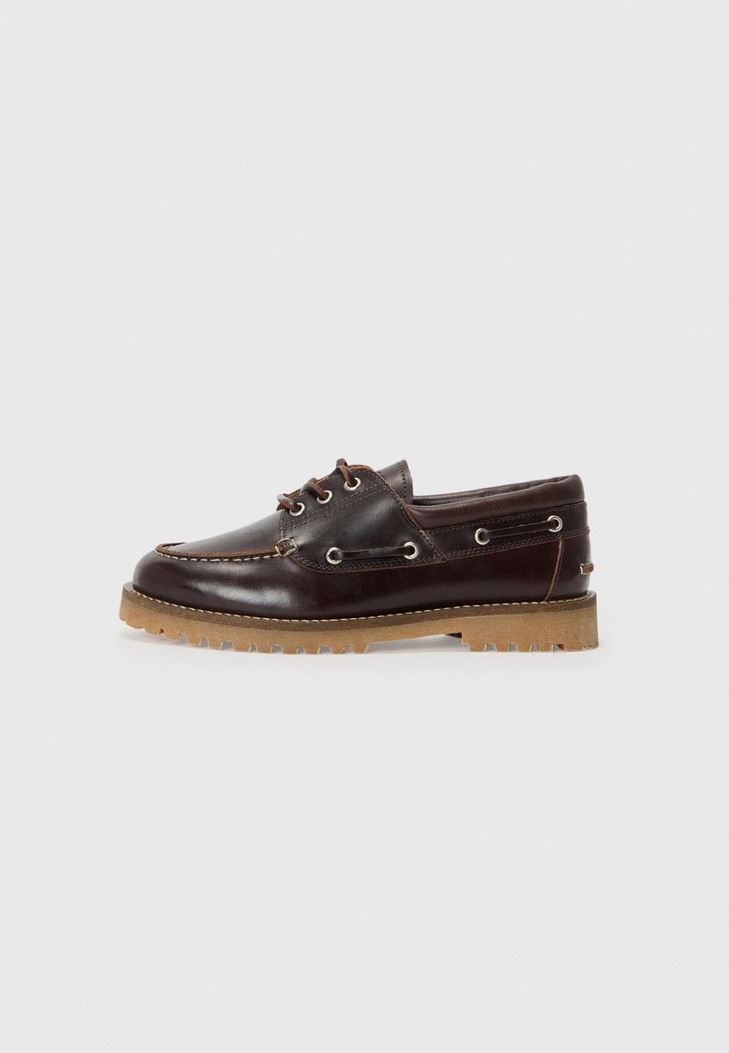 Bateaux en cuir marron avec lacets, œillets en métal et semelle en caoutchouc texturé. Présente des détails de couture et un design à bout arrondi.
