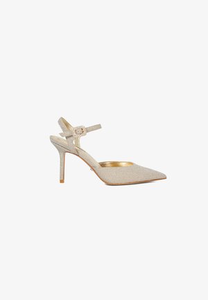 Beige pointed-toe high heel with ankle strap and decorative buckle, textured surface, and gold inner lining.