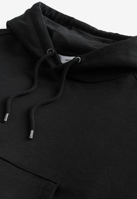 Sort hoodie med justerbare snore, et tykt, struktureret stof og en frontlomme. Har et klassisk design med en hyggelig hætte.