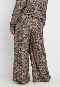 Leopardmönstrade vida byxor i mjukt tyg i beige och bruna nyanser. Har en avslappnad passform och fullängd.