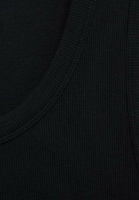 Zwarte tanktopstof met ribbelstructuur, met een brede halslijn en versterkte randen, waarmee het soepele, rekbare materiaal benadrukt wordt.