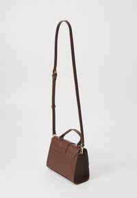 Brown leather handbag with a structured shape, featuring a top handle, an adjustable strap, and gold hardware accents.