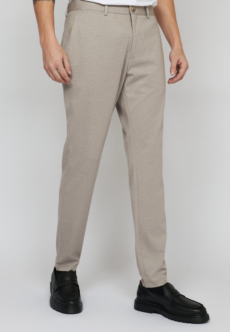 Pantaloni bej deschis, dintr-un material texturat, cu o croială slim, picioare drepte și o închidere cu nasture la talie.