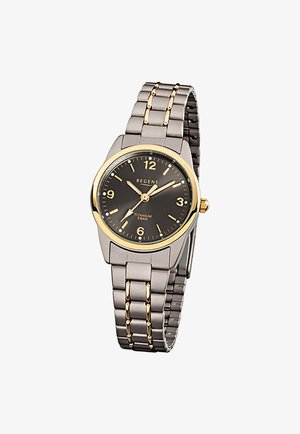 Montre-bracelet en titane avec cadran noir, lunette en or, bracelet en métal argenté avec accents dorés, et affichage analogique montrant 10:08:36.