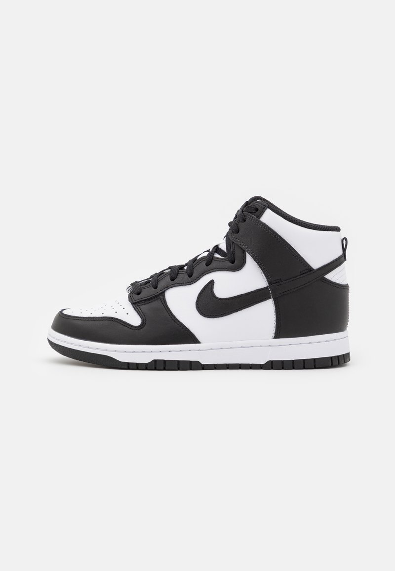 Sneakers alte con un design in pelle bianca e nera, dotate di punta perforata, chiusura con lacci e suola in gomma. Logo Nike in evidenza.