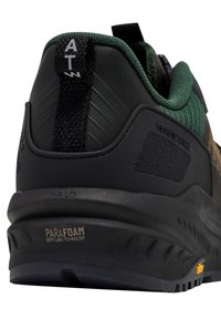 Zwarte en groene sportieve schoen met een gestructureerde hak, Parafoam-technologie, een trekflap en een rubberen zool met een patroon. 
