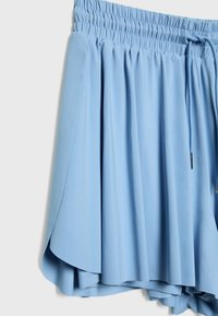 Pantaloni corti plissettati blu con vita elastica, cordoncino e tessuto morbido. Presentano una silhouette fluida e una texture liscia.